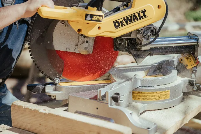 a man using a circular saw to cut a piece of wood